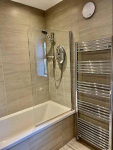 a shower with a glass door in a bathroom at Rockview Beadnell - Perfect Family Retreat in Beadnell