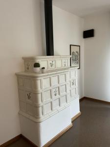 a white fireplace in a room with a wall at La Casa degli Orologi in Belluno