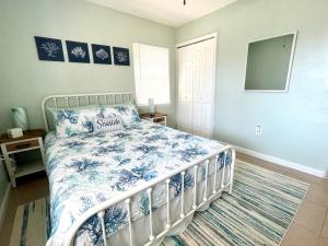 a bedroom with a bed with a blue and white comforter at Beach Bungalow in downtown Cocoa Beach in Cocoa Beach