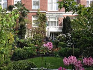 a garden in front of a house with flowers at Vondelparkmuseum Inn in Amsterdam