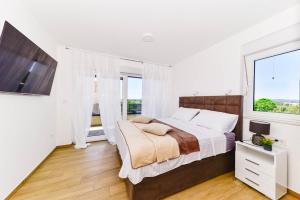 a bedroom with a bed and a large window at Villa Adriatic Sunset in Jadrija