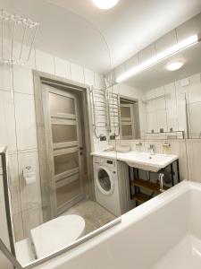 een badkamer met een wastafel en een wasmachine bij Стильні апартаменти в самому Центрі біля Корпусного саду - Мережа HELEN in Poltava