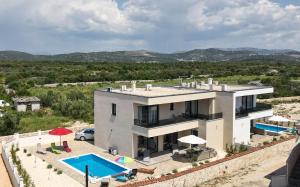 a large house with a swimming pool in front of it at Villa Adriatic Sunset in Jadrija