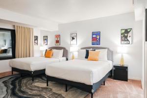 a hotel room with two beds and two lamps at StripViewSuites at Jockey Club in Las Vegas