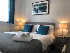 a bedroom with a bed with towels on it at Delight Marvel - Cades Place in Maidstone