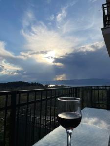 a glass of wine sitting on a table on a balcony at Villa Marta Green in Ohrid
