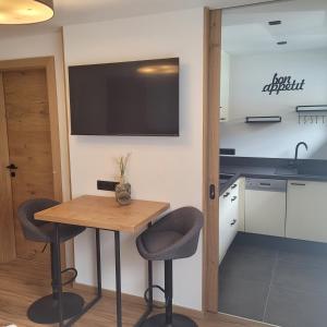 a kitchen with a table and two chairs and a tv on the wall at Apart Bergli in Galtür