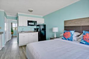 1 dormitorio con 1 cama grande y cocina en Admiral's Quarters en Kure Beach