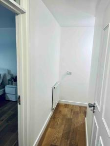 a hallway with a white door and a wooden floor at Lovely 1 Bed, Northolt Station in Northolt