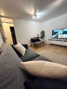 ein Wohnzimmer mit einem Sofa und einem großen TV in der Unterkunft Lovely 1 Bed, Northolt Station in Northolt