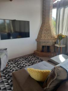 a living room with a fireplace and a couch at Cantin da Mata in Domingos Martins