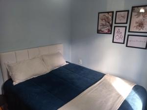 a bed in a bedroom with pictures on the wall at Cantin da Mata in Domingos Martins