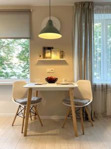 a table and chairs in a kitchen with a light fixture at New Modern Apartments in the City Center in Narva