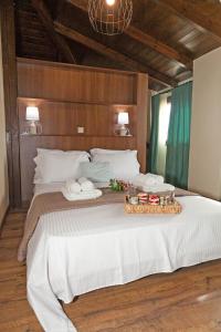 duże białe łóżko z tacą z jedzeniem w obiekcie Villa Alex w miejscowości Agios Georgios