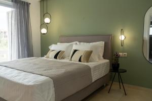1 dormitorio con 1 cama con sábanas y almohadas blancas en Ros Solis Luxure House, en La Canea