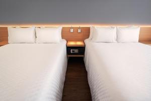 dos camas sentadas una al lado de la otra en una habitación en GAMMA Querétaro, en Querétaro