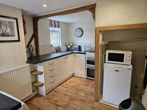 a kitchen with a refrigerator and a microwave at Perfectly Located Pretty Cottage in Diss
