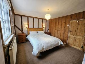 a bedroom with a large bed and a window at Perfectly Located Pretty Cottage in Diss