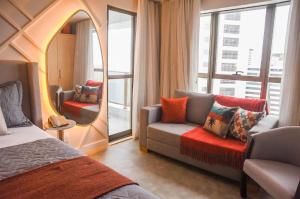 a bedroom with a mirror and a couch and a chair at VISTA MAR BOA VIAGEM - BEACH CLASS EXECUTIVE in Recife