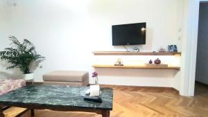 a living room with a coffee table and a flat screen tv at Comfy apartment in Athens
