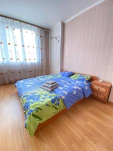 een slaapkamer met een bed met een blauw dekbed bij FlatService Двокімнатні апартаменти в ЖК "4 сезони" in Kiev