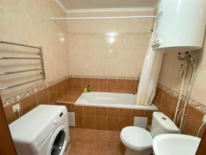 a bathroom with a toilet and a bath tub at FlatService Двокімнатні апартаменти в ЖК "4 сезони" in Kyiv