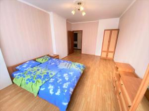 um quarto com uma cama e piso em madeira em FlatService Двокімнатні апартаменти в ЖК "4 сезони" em Kiev