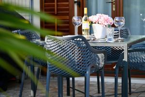 stół z krzesłami, kieliszki do wina i kwiaty na nim w obiekcie Sea Star Apartment w Koprze