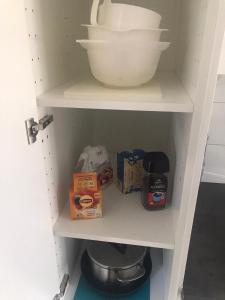 a cupboard with a bowl and boxes of food at Nice Entire Semi - Attached House - M in Umeå