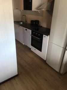 a kitchen with white cabinets and a stove and a refrigerator at Nice Entire Semi - Attached House - M in Umeå