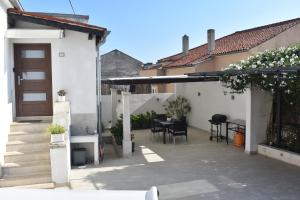 een patio van een huis met een tafel en stoelen bij Holiday House Tina in Pula