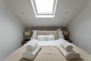 um quarto com uma cama branca e toalhas em Boutique Old Sea Stable - 1 minute from beach em Tynemouth