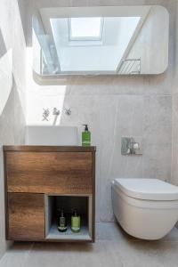 a bathroom with a sink and a toilet and a mirror at Boutique Old Sea Stable - 1 minute from beach in Tynemouth