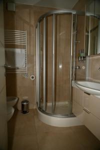 een badkamer met een douche, een toilet en een wastafel bij Sea Star Apartment in Koper