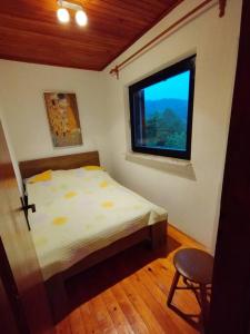 a small bedroom with a bed and a window at Mini hiška v objemu vinograda in Pristava pri Mestinju