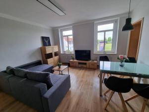 a living room with a couch and a glass table at Gemütliche Wohnung bei Leipzig in Schkeuditz