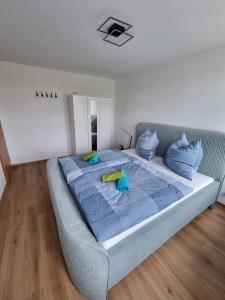 a bedroom with a large bed with blue sheets and pillows at Gemütliche Wohnung bei Leipzig in Schkeuditz