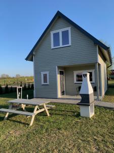ein Haus mit einem Picknicktisch vor einem Haus in der Unterkunft Domki u Karola in Rewal