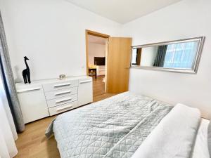 a white bedroom with a bed and a window at Riverside luxury apartment in Bratislava