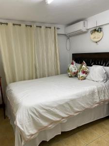 Schlafzimmer mit einem Bett mit weißer Bettwäsche und Kissen in der Unterkunft Marys Cottage 