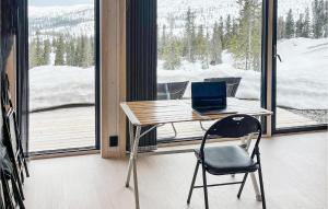 una scrivania con un computer portatile di fronte a una finestra di Cozy Apartment In Fl With Kitchen a Flå