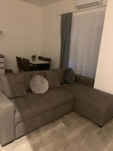 un divano marrone in un soggiorno con tavolo di Vecchie Mura G a Santo Stefano di Magra