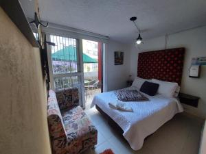 a bedroom with a bed and a large window at Hotel Boutique San Sebastián Chapinero in Bogotá