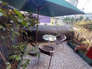 a patio with a table and chairs and an umbrella at Hotel Boutique San Sebastián Chapinero in Bogotá