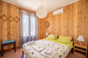 1 dormitorio con paredes de madera y 1 cama con toallas. en Milos studios & Beach House, en Frangokastello