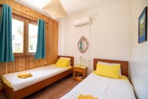 2 camas individuales en una habitación con cortinas azules en Milos studios & Beach House, en Frangokastello