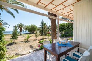 a table and chairs on a porch with a view of the ocean at Milos Alexandra Studio in Frangokastello