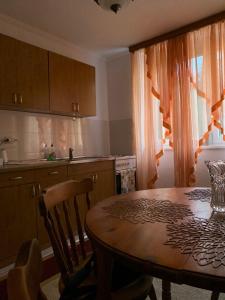 a kitchen with a wooden table and a kitchen with a table and chairs at Apartman Ilidža Pejton in Sarajevo