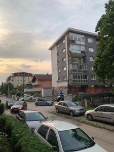 a parking lot with cars parked in front of a building at Apartman Ilidža Pejton in Sarajevo