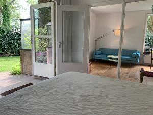 a bedroom with a bed and a blue couch at Loveland in Bergen